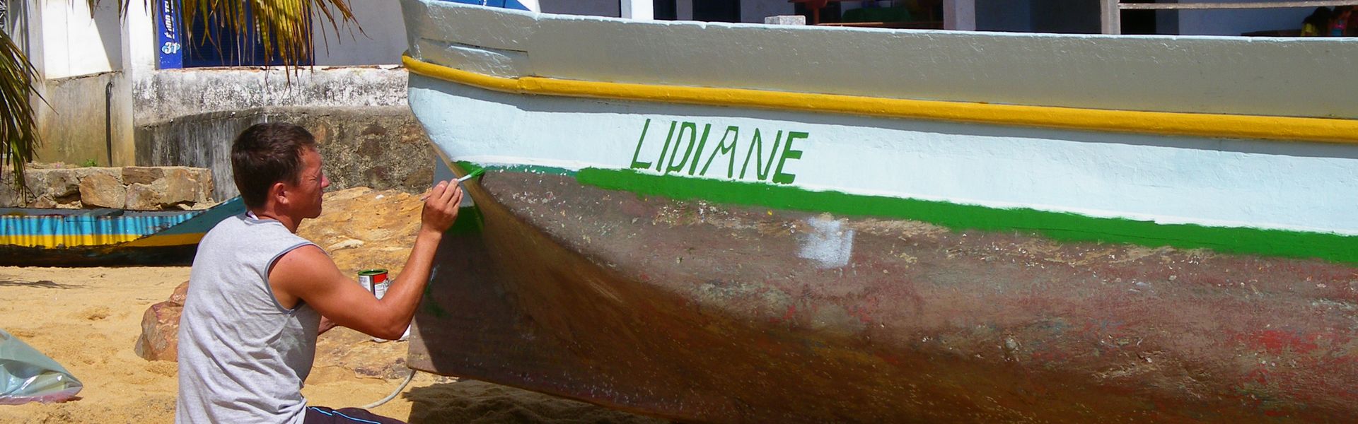 Un pêcheur peint la coque de son bateau à parnaïba au Brésil